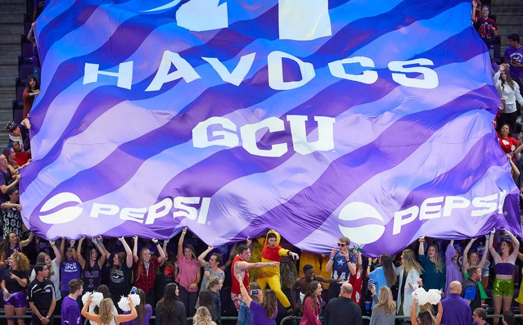 GCU Havocs student section holding up sponsored flag in GCU Arena