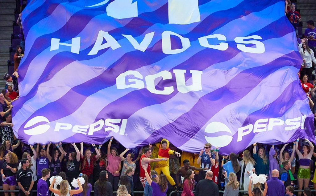 GCU Havocs student section holding up sponsored flag in GCU Arena 