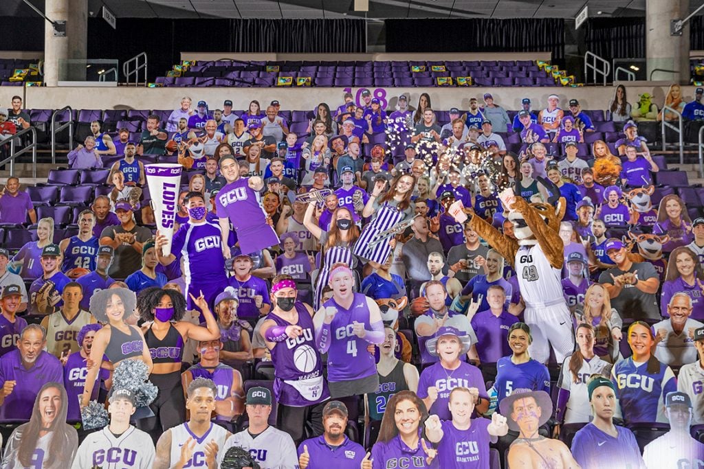 Students holding cardboard cutouts in the bleachers at the GCU Arena